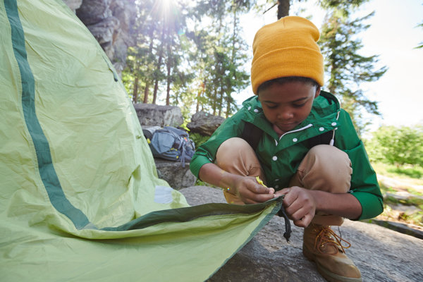 Involve the kids when setting up camp - Image of boy setting up the tent