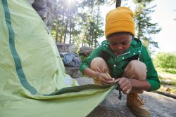 Involve the kids when setting up camp - Image of boy setting up the tent