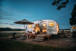 Couple relaxing next to caravan at night