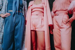 Three women posing with designer clothes.