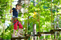 Girl on treetop adventure course