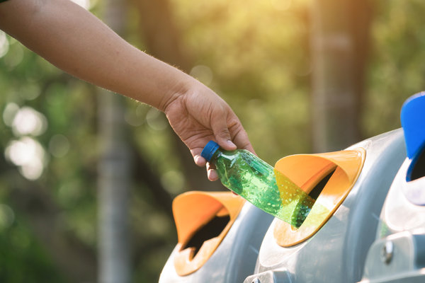 Throwing empty plastic bottle into the trash Recycling