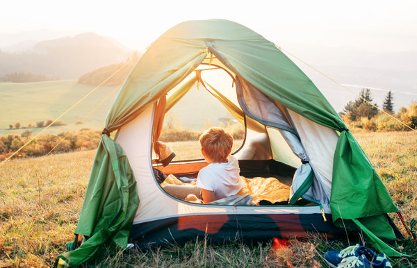 Boy rest in tent and enjoy with sunset